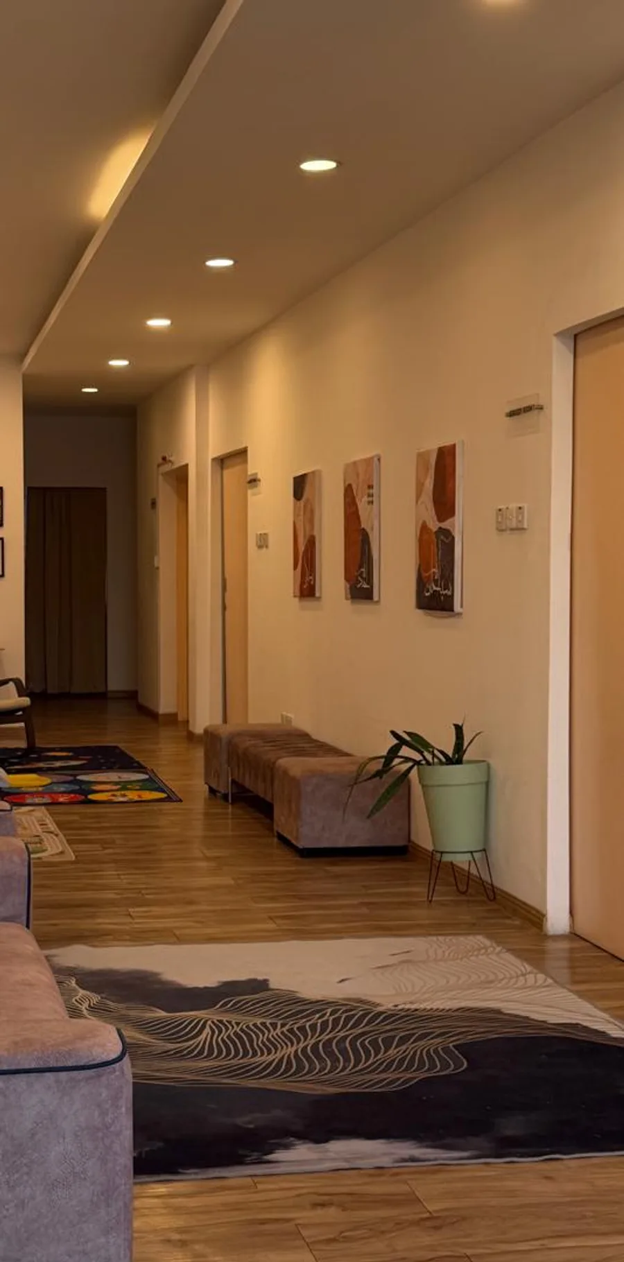 The corridor leading to the treatment rooms, with seating and framed artwork