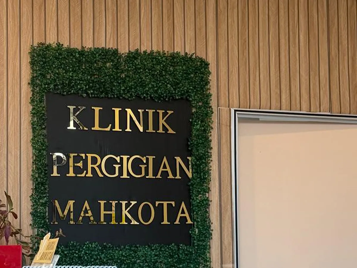 The clinic's name in gold lettering on the green wall behind reception